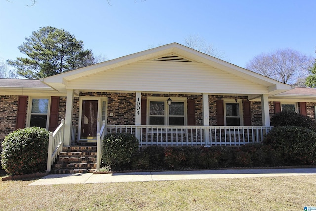 view of front of property with covered porch and brick siding