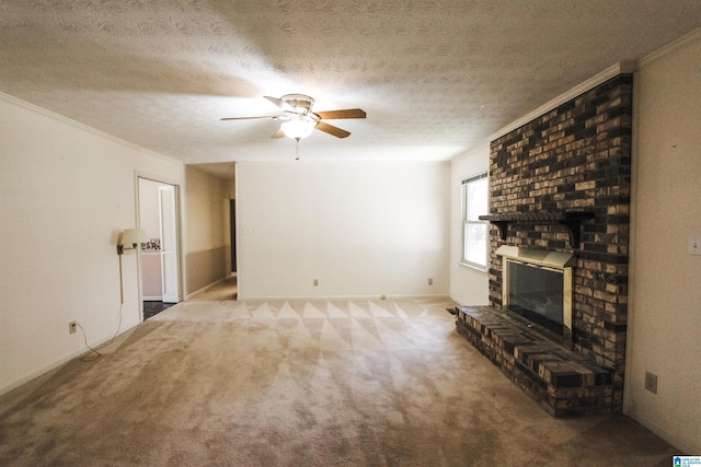 unfurnished living room with a ceiling fan, ornamental molding, a textured ceiling, carpet flooring, and a fireplace