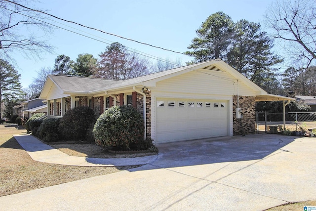 view of side of home with driveway, a garage, fence, and brick siding