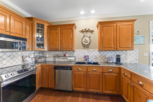 kitchen with brown cabinets, glass insert cabinets, stainless steel appliances, and a sink