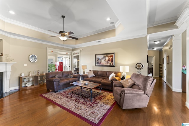 living area with a tray ceiling, dark wood-style flooring, crown molding, a premium fireplace, and baseboards