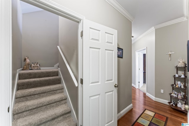 staircase with ornamental molding, baseboards, and wood finished floors