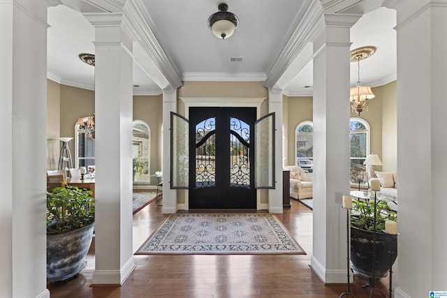 entrance foyer with ornate columns, plenty of natural light, and wood finished floors