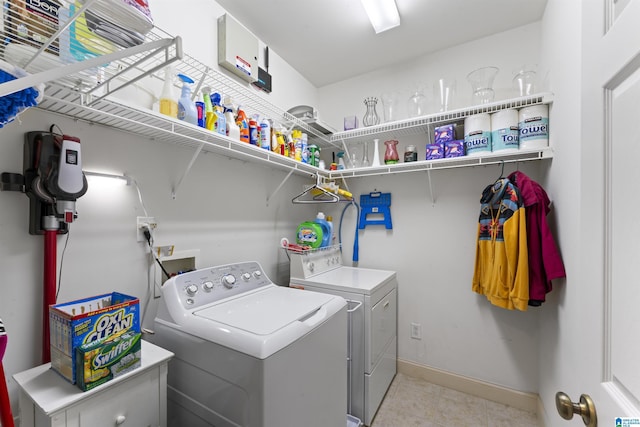 washroom featuring laundry area, light tile patterned floors, baseboards, and washer and clothes dryer