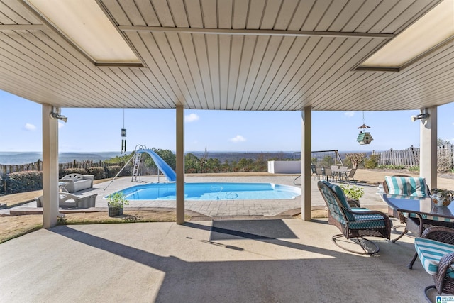 view of patio with fence and an outdoor pool