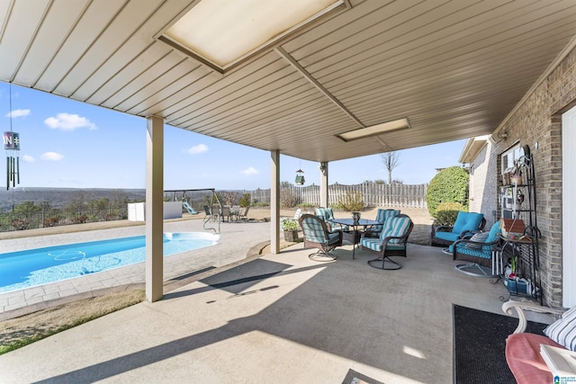 view of patio with outdoor dining space, a fenced backyard, and a fenced in pool