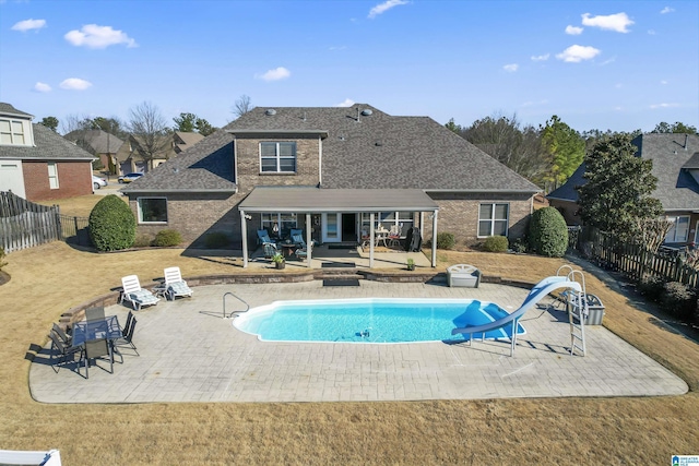 view of pool with a patio, a water slide, an outdoor fire pit, a fenced backyard, and a fenced in pool