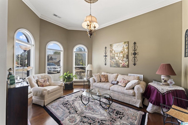 living room with ornamental molding, wood finished floors, visible vents, and a healthy amount of sunlight