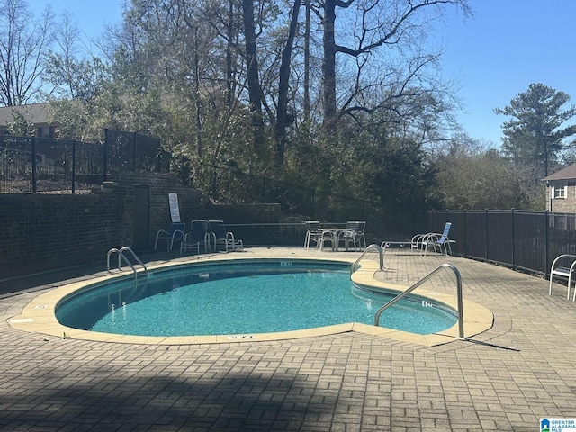 pool with a patio and fence