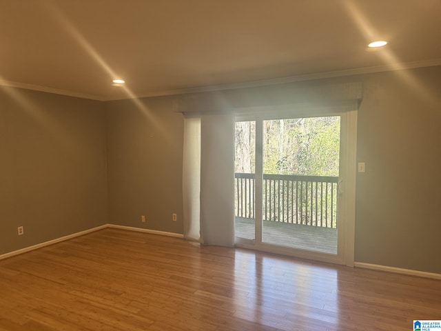 spare room with baseboards, ornamental molding, wood finished floors, and recessed lighting