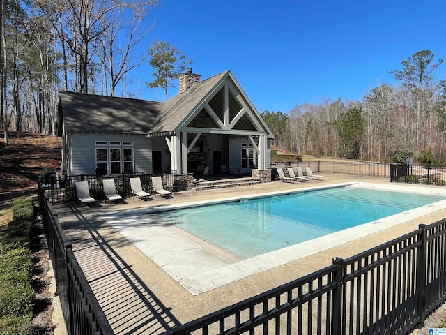 pool with a patio area and fence