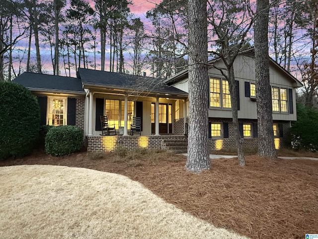 split level home with covered porch and brick siding