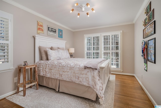 bedroom with baseboards, wood finished floors, and crown molding