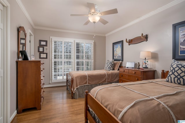 bedroom featuring a ceiling fan, baseboards, ornamental molding, and wood finished floors