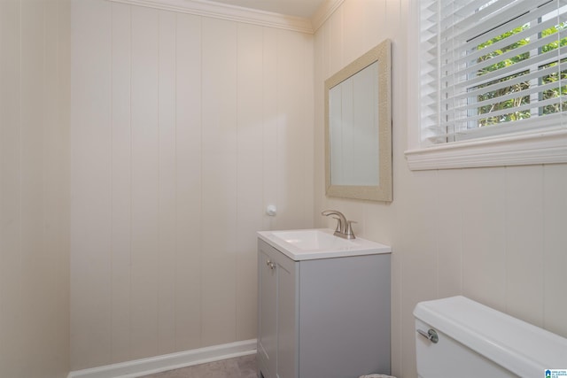 bathroom with ornamental molding, vanity, toilet, and baseboards