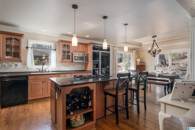 kitchen featuring a sink, a kitchen breakfast bar, a center island, black appliances, and dark countertops