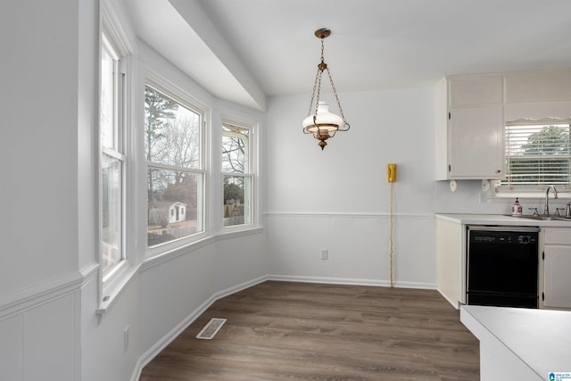 kitchen featuring a sink, wood finished floors, visible vents, wainscoting, and dishwasher