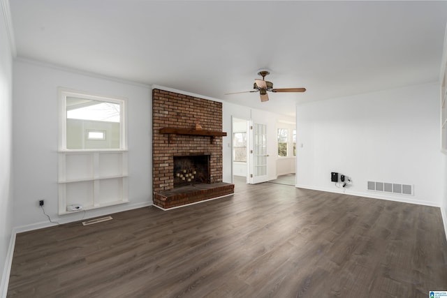 unfurnished living room with visible vents, a fireplace, baseboards, and wood finished floors