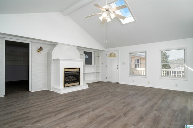 unfurnished living room featuring a ceiling fan, a fireplace with raised hearth, dark wood-type flooring, and beamed ceiling