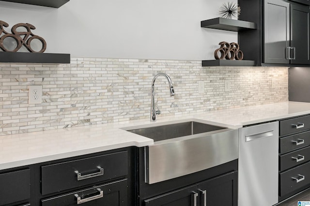 kitchen featuring open shelves, dark cabinetry, and a sink