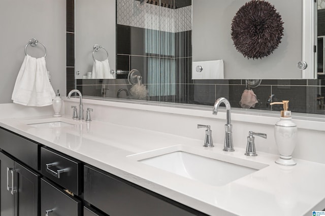 full bathroom featuring a sink, backsplash, and double vanity