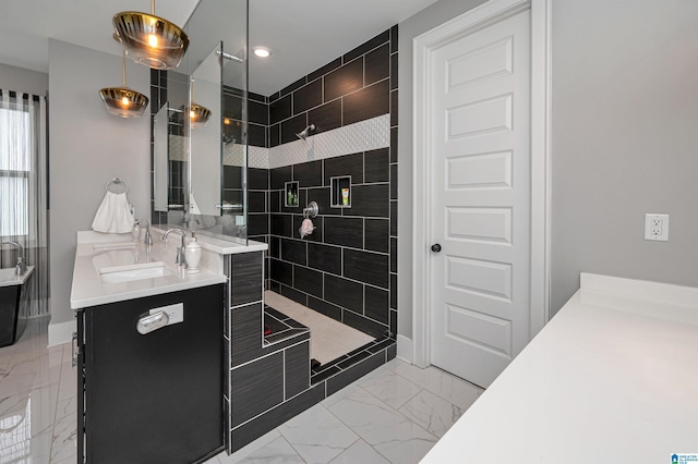 bathroom featuring marble finish floor, vanity, baseboards, and a walk in shower