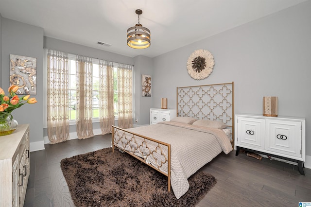 bedroom featuring dark wood-style floors, visible vents, and baseboards