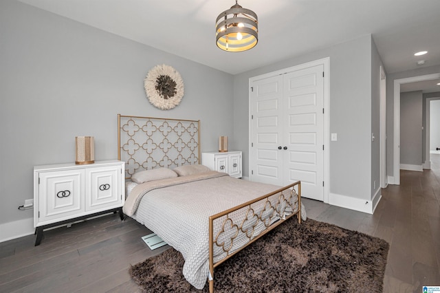 bedroom featuring baseboards, dark wood-style flooring, a closet, and recessed lighting