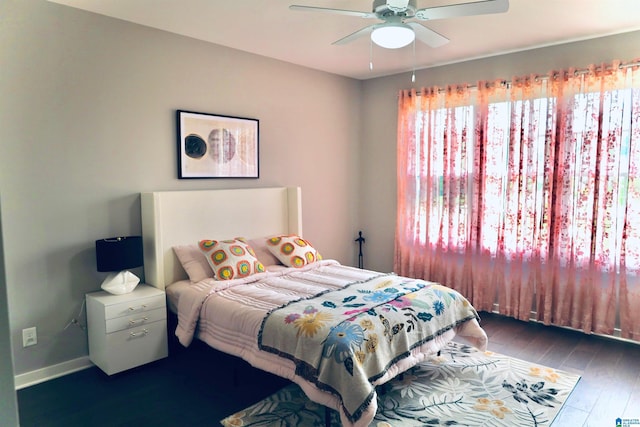 bedroom with ceiling fan, baseboards, and wood finished floors