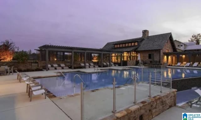 pool with a patio area and a pergola