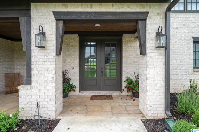 doorway to property featuring brick siding and french doors