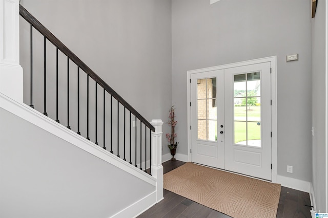 foyer with baseboards, dark wood-type flooring, a high ceiling, stairs, and french doors