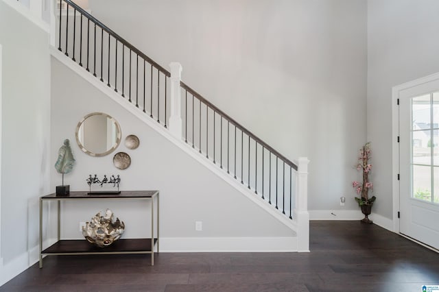 entrance foyer with a high ceiling, stairs, baseboards, and wood finished floors