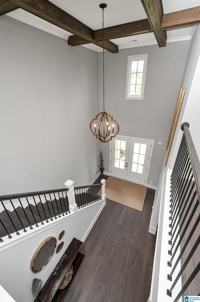 entryway featuring dark wood-style flooring, beamed ceiling, baseboards, and an inviting chandelier