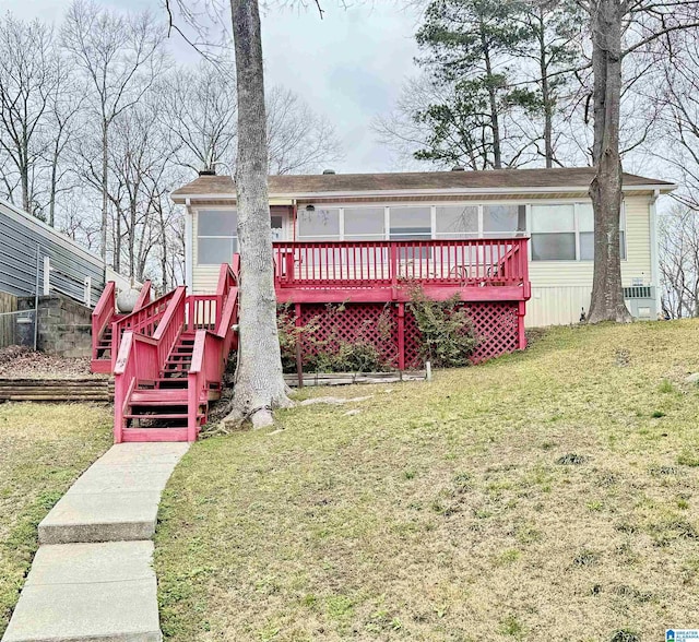 view of front of home with a deck, stairway, and a front lawn