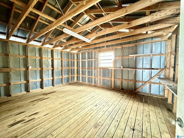 misc room with a garage and wood finished floors