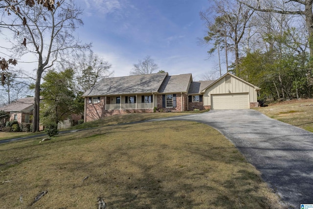 view of front facade with aphalt driveway, a front yard, board and batten siding, and an attached garage