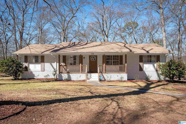 ranch-style house with covered porch, brick siding, and a front yard