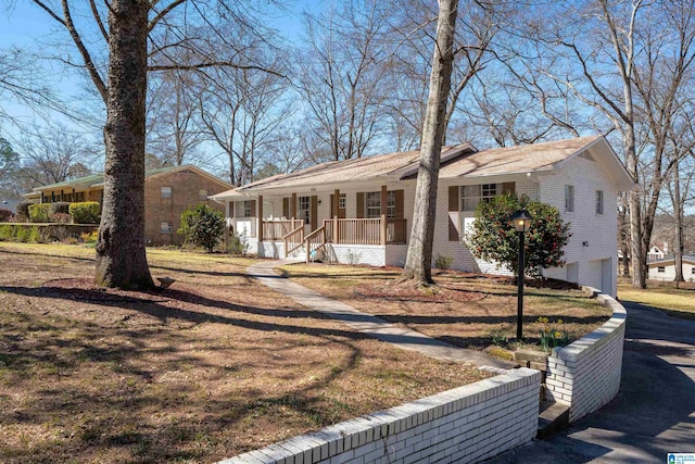 ranch-style home featuring covered porch and brick siding