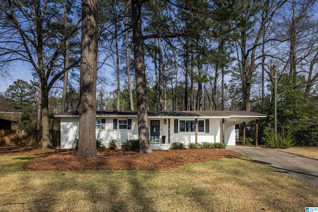 ranch-style house with a carport, concrete driveway, a front lawn, and fence