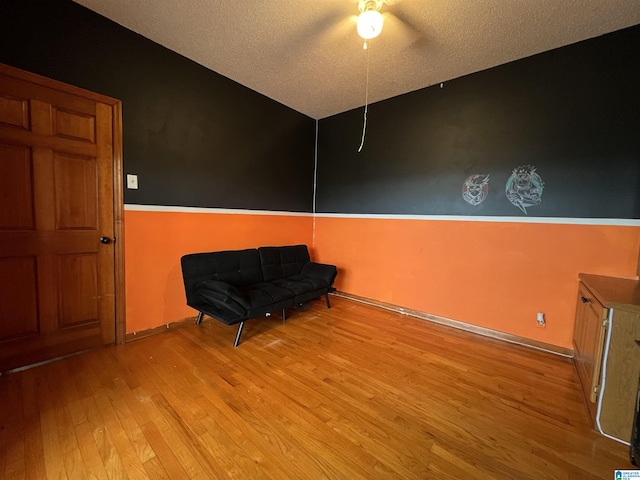 unfurnished room featuring light wood-style floors, baseboards, and a textured ceiling