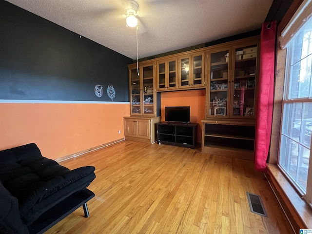 interior space featuring a textured ceiling, visible vents, and wood finished floors