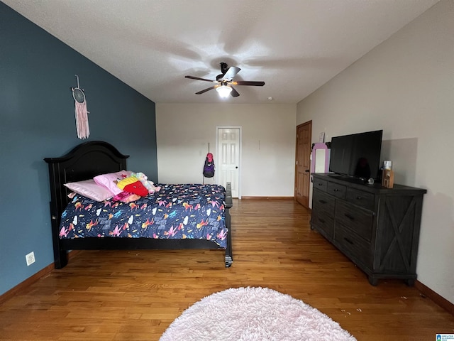 bedroom with ceiling fan, baseboards, and wood finished floors