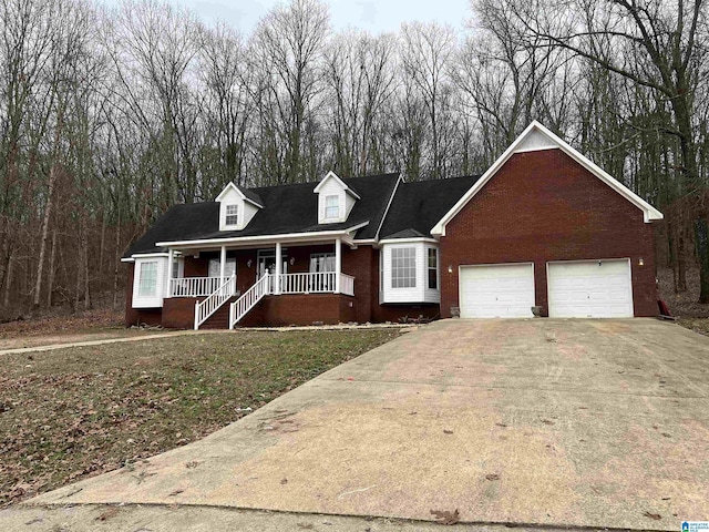 cape cod house featuring a front yard, covered porch, brick siding, and driveway