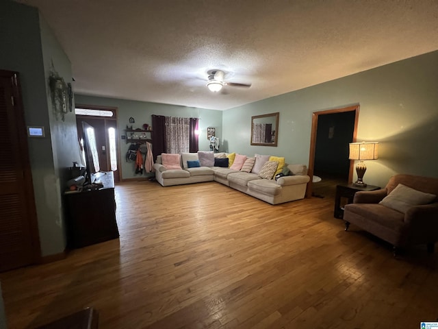 living area with a textured ceiling, a ceiling fan, and wood finished floors