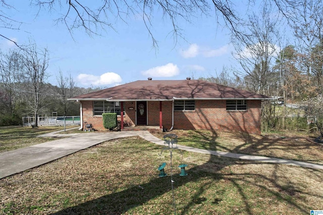 ranch-style house featuring driveway, a front lawn, and brick siding