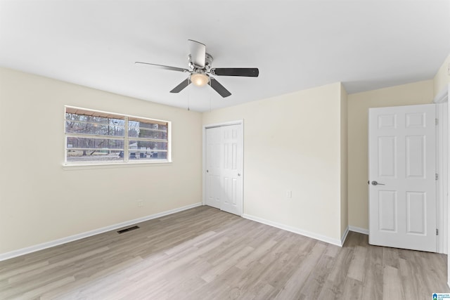 unfurnished bedroom with a closet, visible vents, light wood-style flooring, a ceiling fan, and baseboards