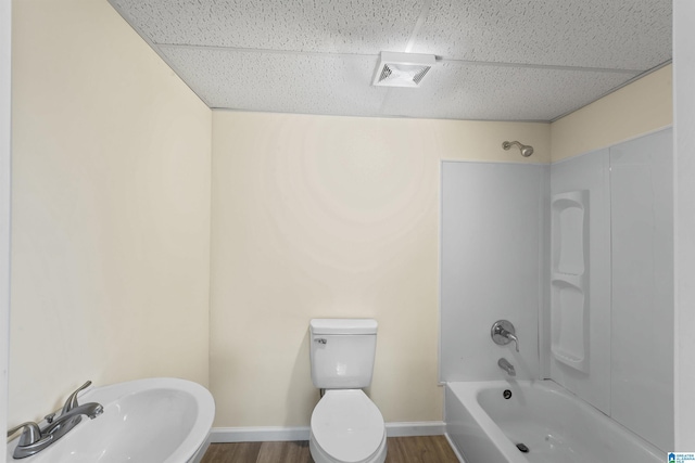 full bathroom with a paneled ceiling, toilet, and wood finished floors