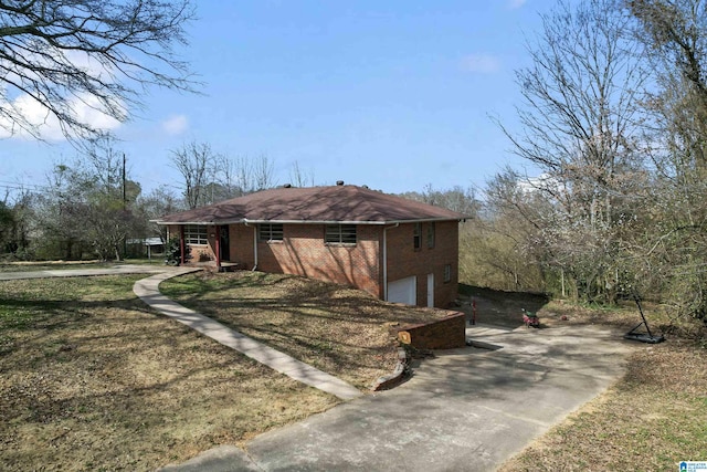 view of front of property featuring a garage, a front yard, concrete driveway, and brick siding