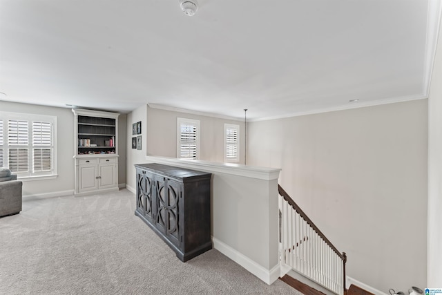 corridor with a healthy amount of sunlight, baseboards, light colored carpet, and an upstairs landing